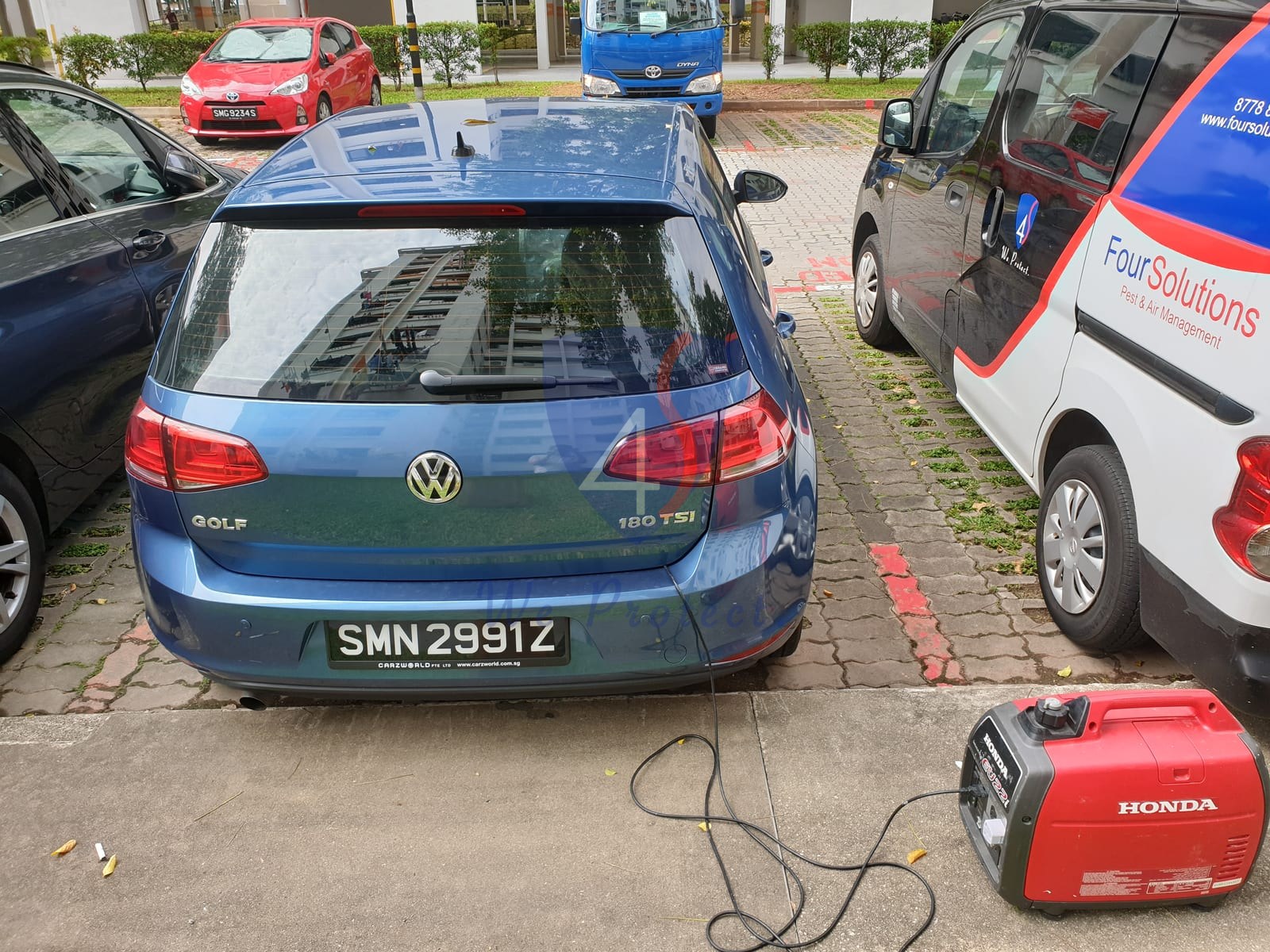 Four Solutions technician fumigating a car with a professional ULV fogging machine in Singapore